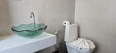 a bathroom with a bowl sink on top of a toilet at APK Hillview Hotel in Patong Beach