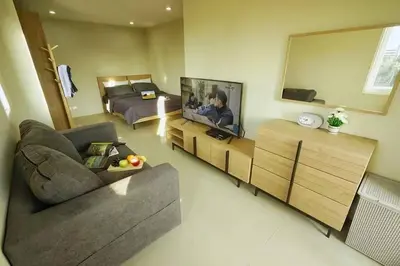 a living room with a couch and a bed and a television at Phuket Avenue in Phuket Old Town in Phuket Town