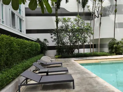 a group of lounge chairs next to a swimming pool at 4 Floor - The Base Downtown Condominium next to Central Shopping Mall in Phuket Town