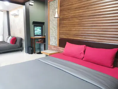 a bedroom with a large bed with pink pillows at Ingsala by CafeAtLuv22 in Ban Bo Rae