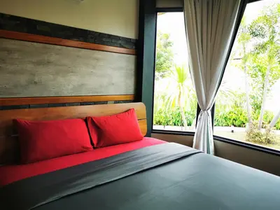 a bedroom with a bed with red pillows and a window at Ingsala by CafeAtLuv22 in Ban Bo Rae