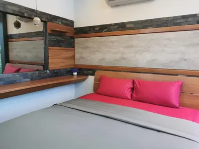 a bedroom with a bed with pink pillows at Ingsala by CafeAtLuv22 in Ban Bo Rae