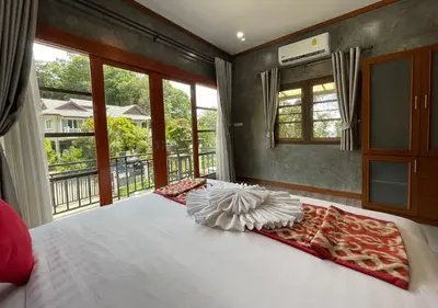 a bedroom with a white bed with a window at Charming and Exotic Seaview 2-Bedroom House in Patong in Patong Beach