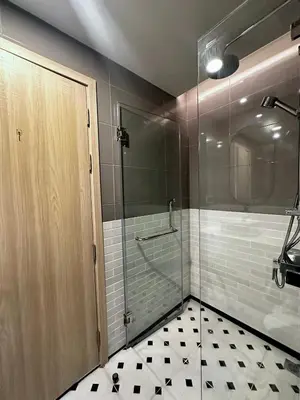 a bathroom with a shower and a glass door at Palmetto Park Condominium in Karon Beach