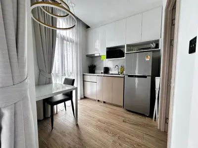 a small kitchen with a table and a refrigerator at Palmetto Park Condominium in Karon Beach
