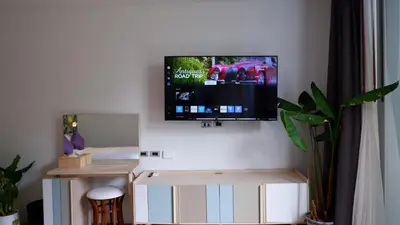 a living room with a tv on a wall at The Lush Apartments & Suites in Pilai Beach