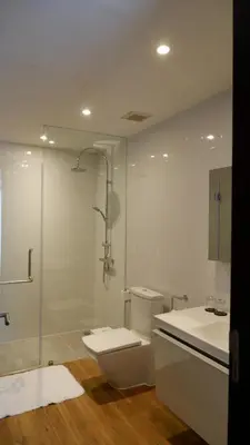 a bathroom with a shower and a toilet and a sink at The Lush Apartments & Suites in Pilai Beach