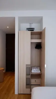 a room with a bed and a closet with shoes at The Lush Apartments & Suites in Pilai Beach