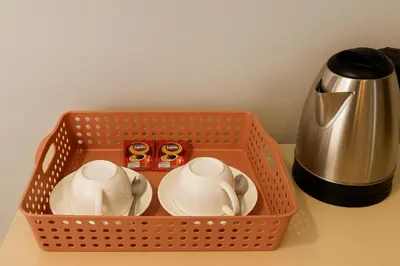 an orange basket with two cups and a tea kettle at Srisuksan Klong Muang Beach in Klong Muang Beach