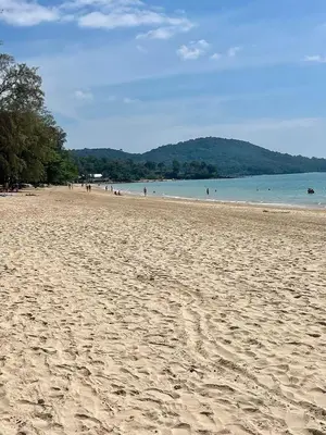 a sandy beach with people swimming in the water at Srisuksan Klong Muang Beach in Klong Muang Beach