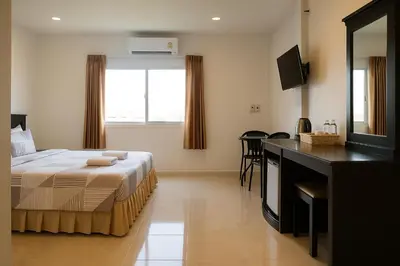 a bedroom with a bed and a desk and a television at Srisuksan Klong Muang Beach in Klong Muang Beach