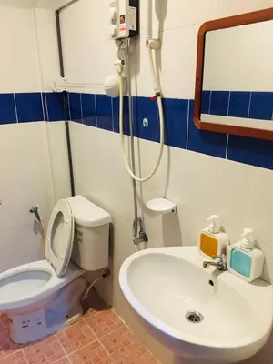 a bathroom with a toilet and a sink and a mirror at Srisuksan Klong Muang Beach in Klong Muang Beach