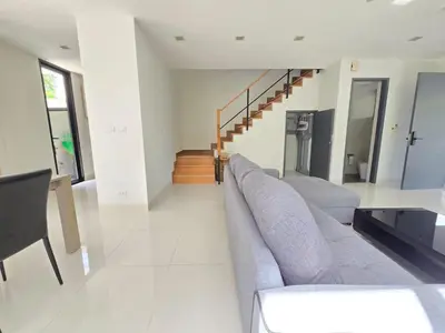 a living room with a couch and a staircase at Laguna Park 2 Villa 3 bedroom in Ban Phru Champa