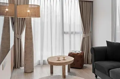 a living room with a couch and a table in front of a window at Laguna Lakeside BangTao Лагуна Лейксайд Lagoona operated by OK Group in Bang Tao Beach