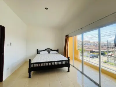 a bedroom with a bed and a large window at Winlee house in Ban Phlu Yai
