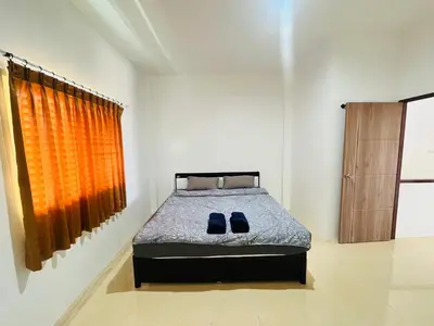 a bedroom with a bed with blue shoes on it at Winlee house in Ban Phlu Yai