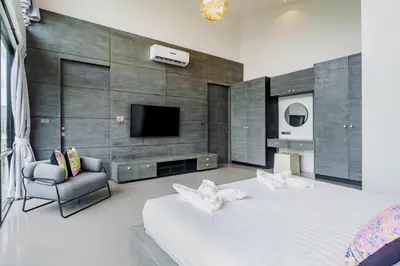 a bedroom with a large white bed and a tv at Harmony Exclusive Villa Bang Tao Phuket in Ban Thalat Choeng Thale