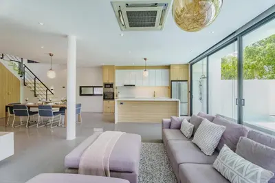a living room with a purple couch and a kitchen at Harmony Exclusive Villa Bang Tao Phuket in Ban Thalat Choeng Thale