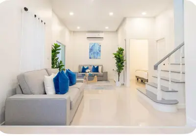 a living room with a couch and blue pillows at Patong Seven Heaven in Patong Beach