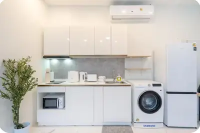 a kitchen with a washing machine and a refrigerator at Patong Seven Heaven in Patong Beach