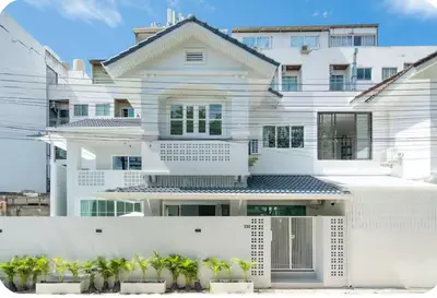 a white house with plants in front of it at Patong Seven Heaven in Patong Beach
