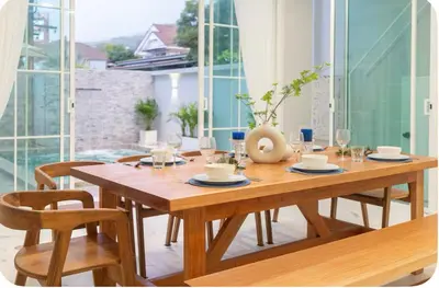 a dining room with a wooden table and chairs at Patong Seven Heaven in Patong Beach