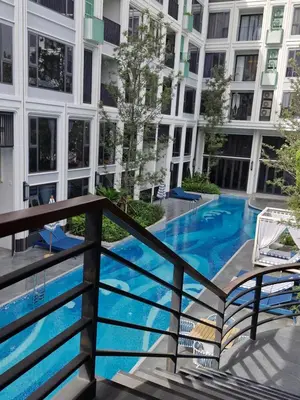 a balcony with a blue swimming pool in a building at Bellevue Lagoon Phuket 212 Bang tao operated by OK Group in Laguna Phuket
