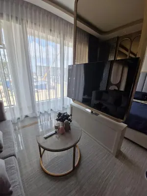 a living room with a large television and a coffee table at Bellevue Lagoon Phuket 212 Bang tao operated by OK Group in Laguna Phuket