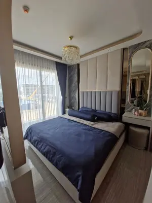 a bedroom with a large blue bed and a mirror at Bellevue Lagoon Phuket 212 Bang tao operated by OK Group in Laguna Phuket