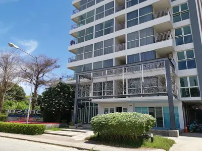 a tall white building with windows and bushes at 6 Floor - Studio room at OZC near Kata beach in Kata Beach