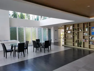 a dining room with chairs and a table and bookshelves at 6 Floor - Studio room at OZC near Kata beach in Kata Beach
