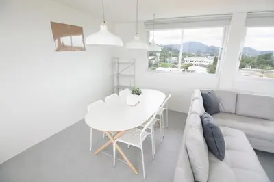 a white living room with a table and a couch at Spacious 2 Bedrooms 360deg Mountain-View Apartment in Ban Klang
