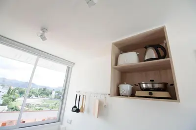 a kitchen with a shelf with utensils and a window at Spacious 2 Bedrooms 360deg Mountain-View Apartment in Ban Klang
