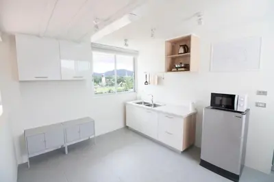 a white kitchen with a sink and a refrigerator at Spacious 2 Bedrooms 360deg Mountain-View Apartment in Ban Klang