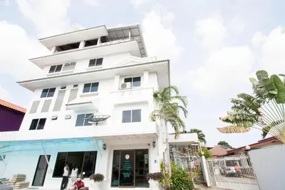 a white building with a palm tree in front of it at Spacious 2 Bedrooms 360deg Mountain-View Apartment in Ban Klang