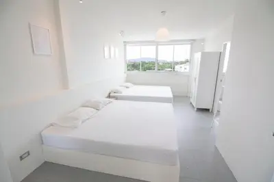 two beds in a white room with a window at Spacious 2 Bedrooms 360deg Mountain-View Apartment in Ban Klang