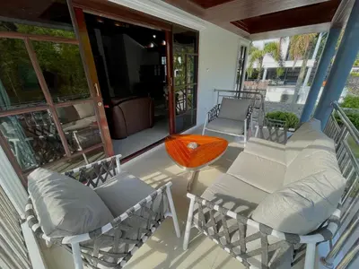 a screened porch with chairs and a table at Kata Tropical Heights Villa - 4BR Private Pool in Kata Beach