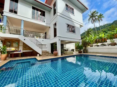 a villa with a swimming pool in front of a house at Kata Tropical Heights Villa - 4BR Private Pool in Kata Beach