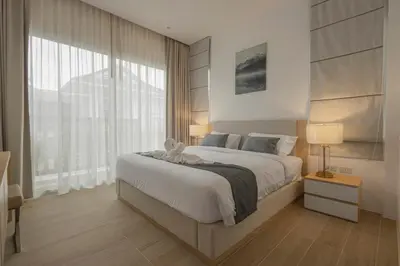 a bedroom with a large bed and a large window at Tantawan house - Kamala beach in Kamala Beach