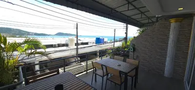 a balcony with tables and chairs and a view of the beach at Andaman Seaview house rooftop 2 in Patong Beach