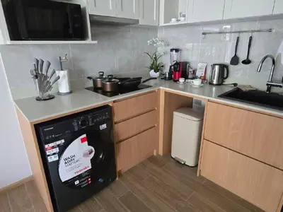 a kitchen with a dishwasher and a counter top at Beachside Lagoon Bang Tao Laguna by OK group in Ban Thalat Choeng Thale