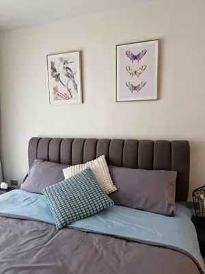 a bed with two pillows and two pictures on the wall at Beachside Lagoon Bang Tao Laguna by OK group in Ban Thalat Choeng Thale