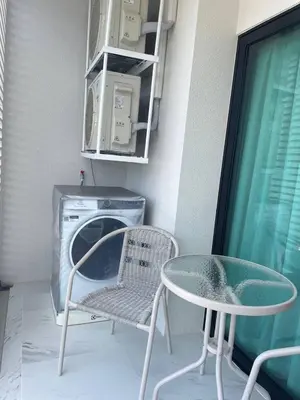 a table and a chair and a washing machine at Coco Calm Title Halo 1 in Koh Lone