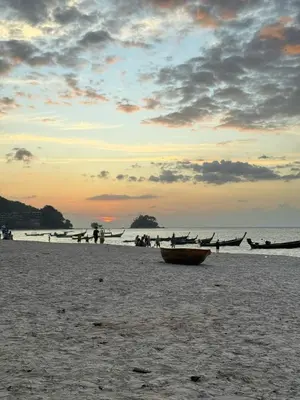 a group of people on a beach with a boat at Coco Calm Title Halo 1 in Koh Lone