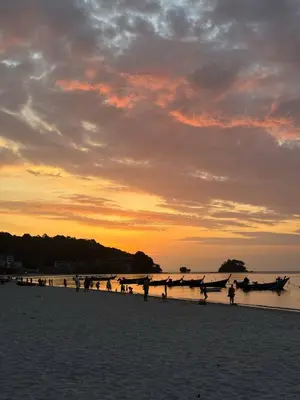 a group of people on the beach at sunset at Coco Calm Title Halo 1 in Koh Lone