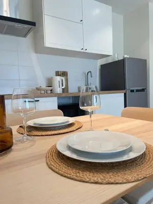 a wooden table with two plates and wine glasses on it at Coco Calm Title Halo 1 in Koh Lone