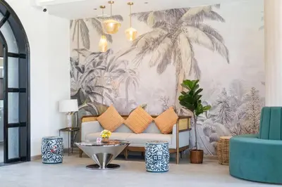 a living room with a couch and a palm mural at Howard Johnson by Wyndham Phuket Naiyang in Thalang