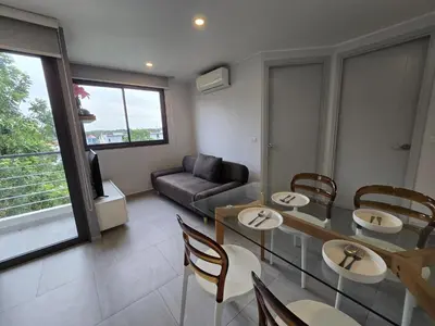 a living room with a table and chairs and a couch at Easy Stay – 2-Bedroom T2-618 in Phuket Town