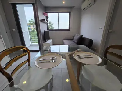 a living room with two chairs and a glass table at Easy Stay – 2-Bedroom T2-618 in Phuket Town