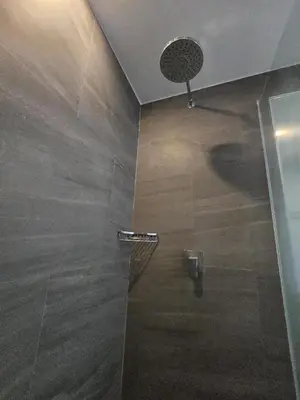 a bathroom with a shower with a man standing in it at Easy Stay – 2-Bedroom T2-618 in Phuket Town